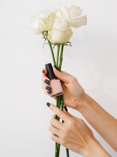 woman-holds-nail-varnish-and-flowers-beauty-salon-U2366SW.jpg